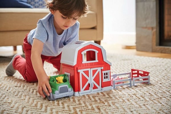 A boy playing with farm playsets