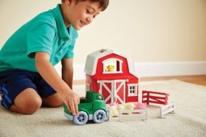 A boy playing with farm playsets